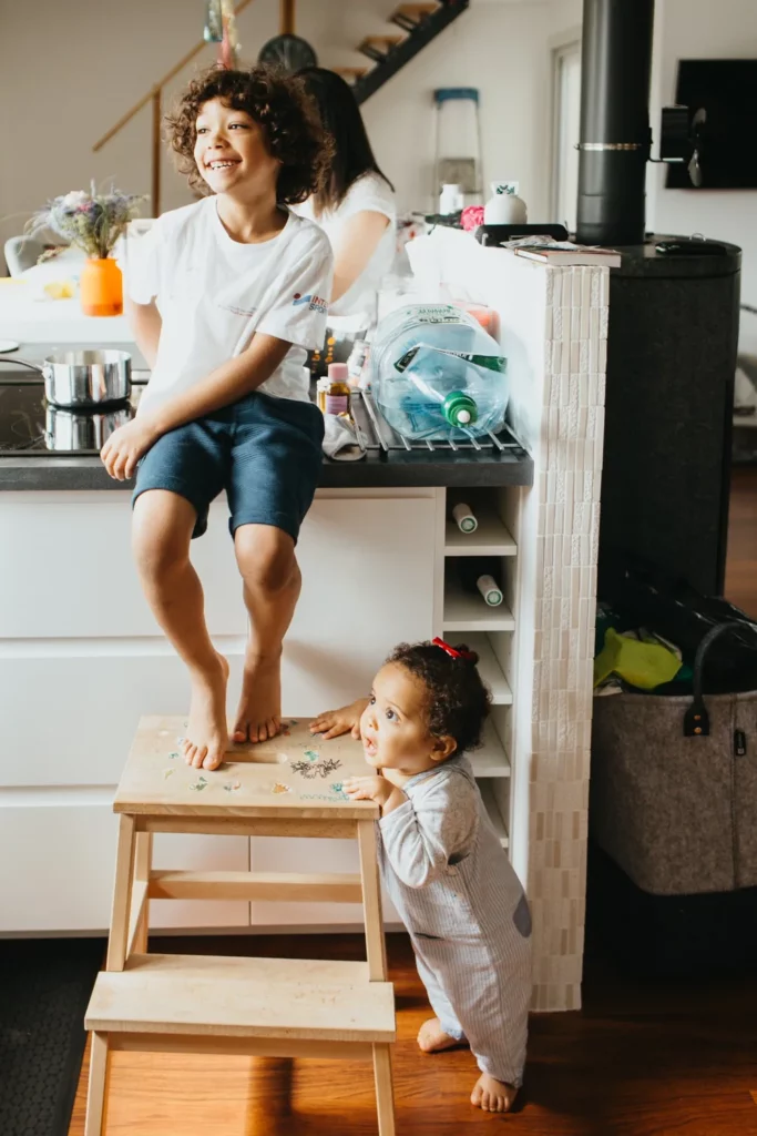 Deux enfants jouant dans la cuisine familiale lors d’une séance photo famille à Bordeaux.